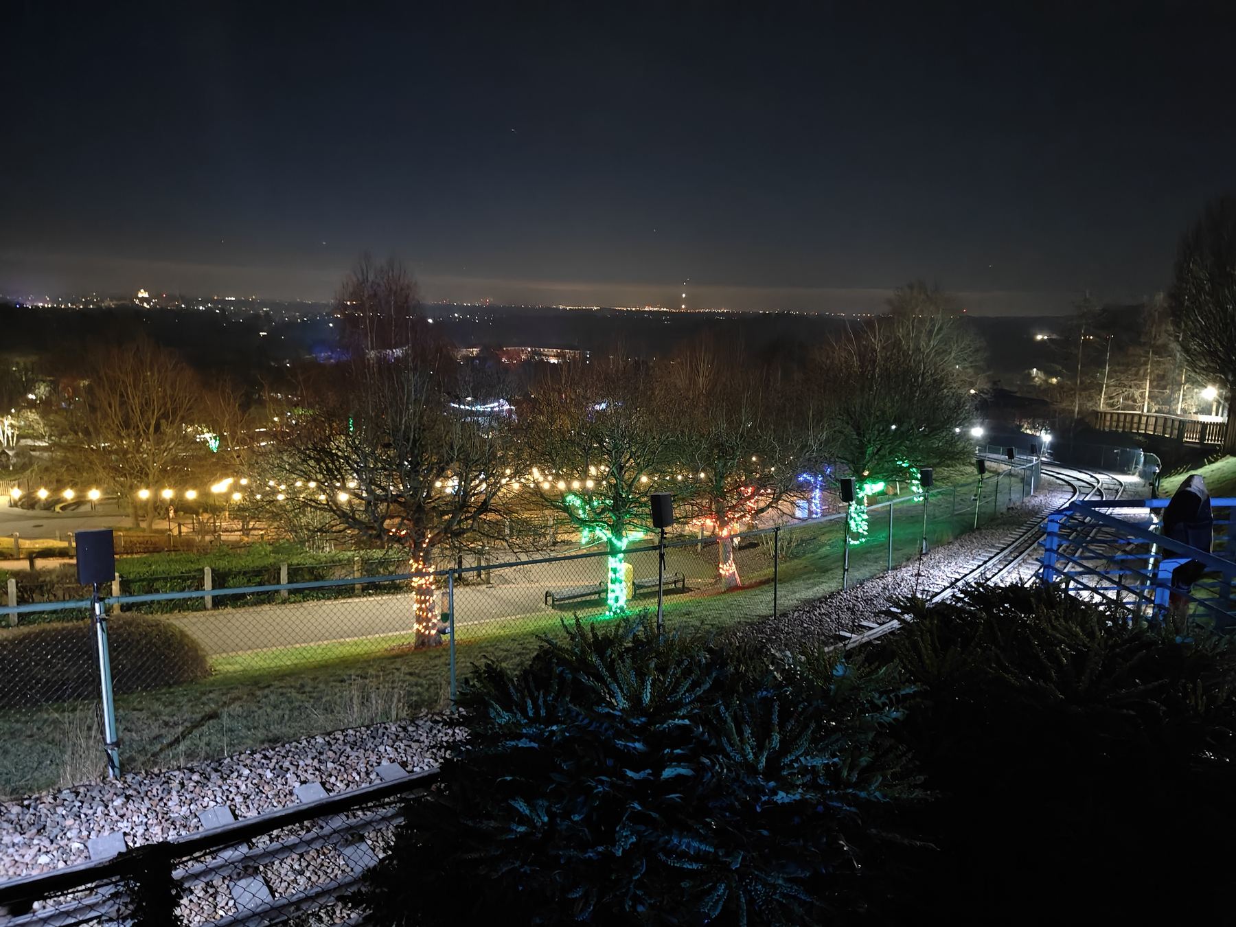 Illuminated park at night with distributed loudspeakers