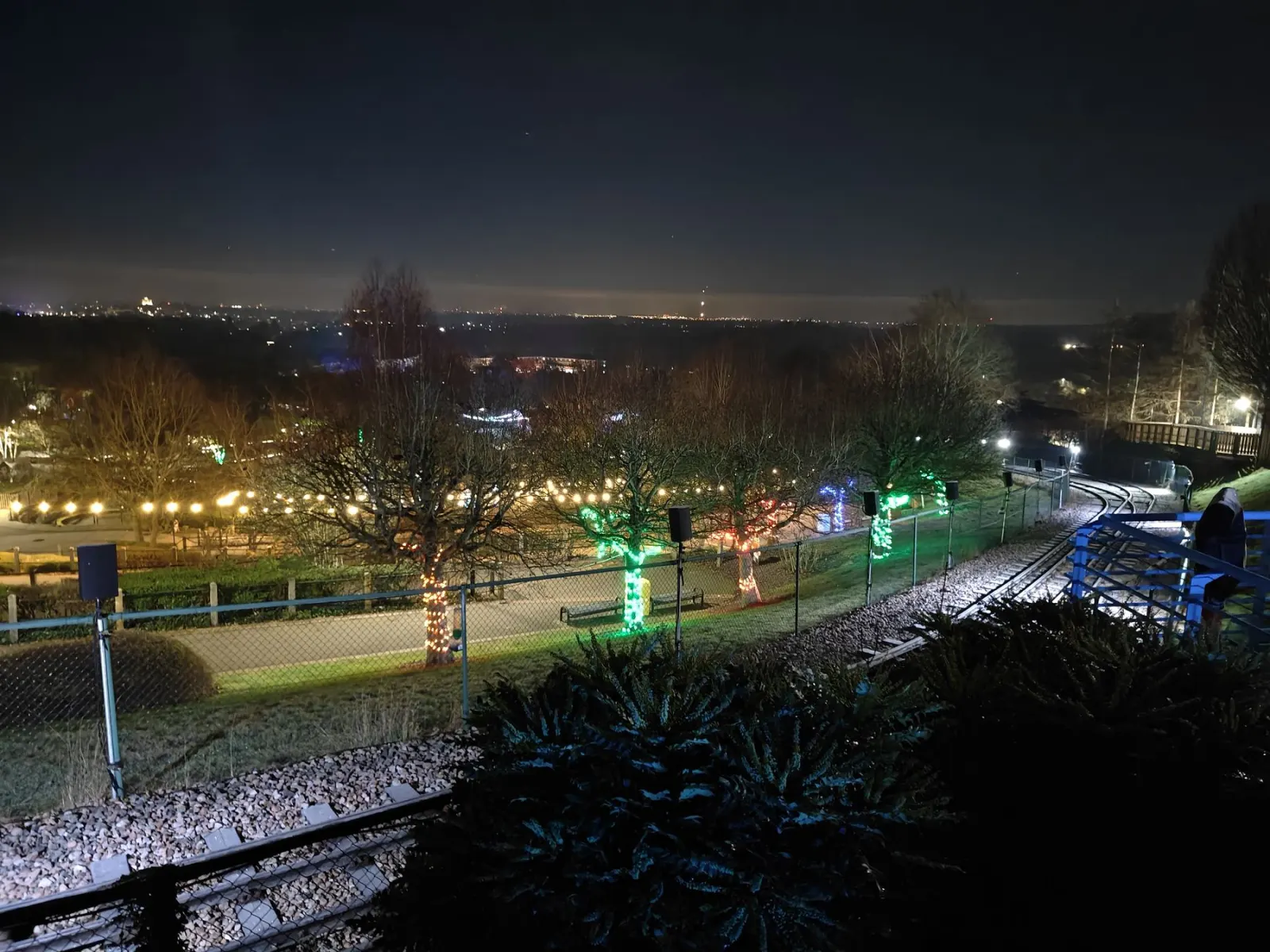 Illuminated park at night with distributed loudspeakers
